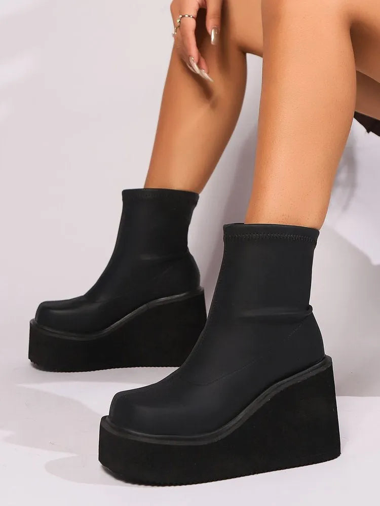 Women's black wedge boot with round toe and high cylinder, showing waterproof platform sole.