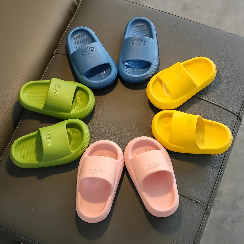 Children's bright coloured EVA slippers with textured non-slip soles, shown in blue, green, orange, pink, and yellow.