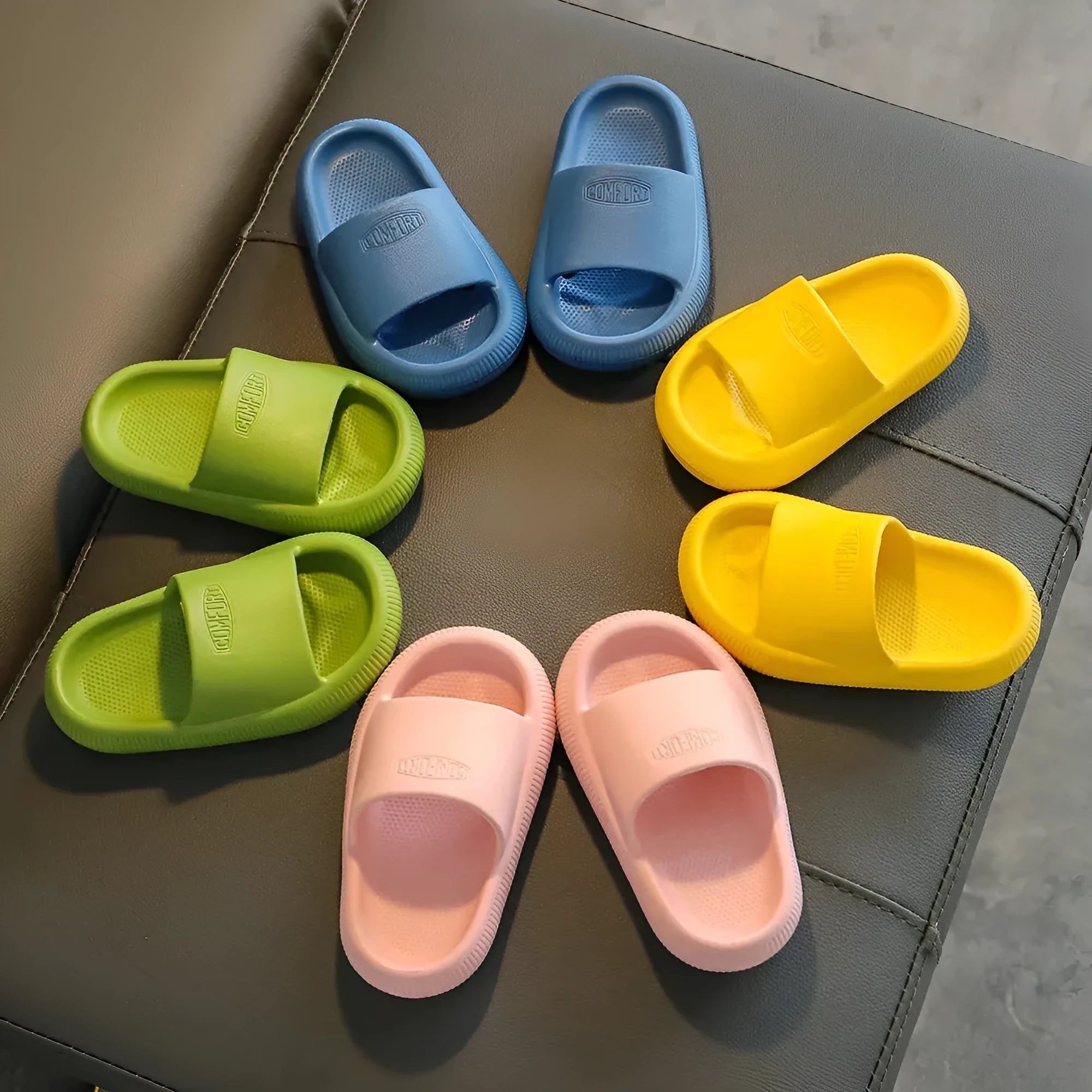 Children's bright coloured EVA slippers with textured non-slip soles, shown in blue, green, orange, pink, and yellow.