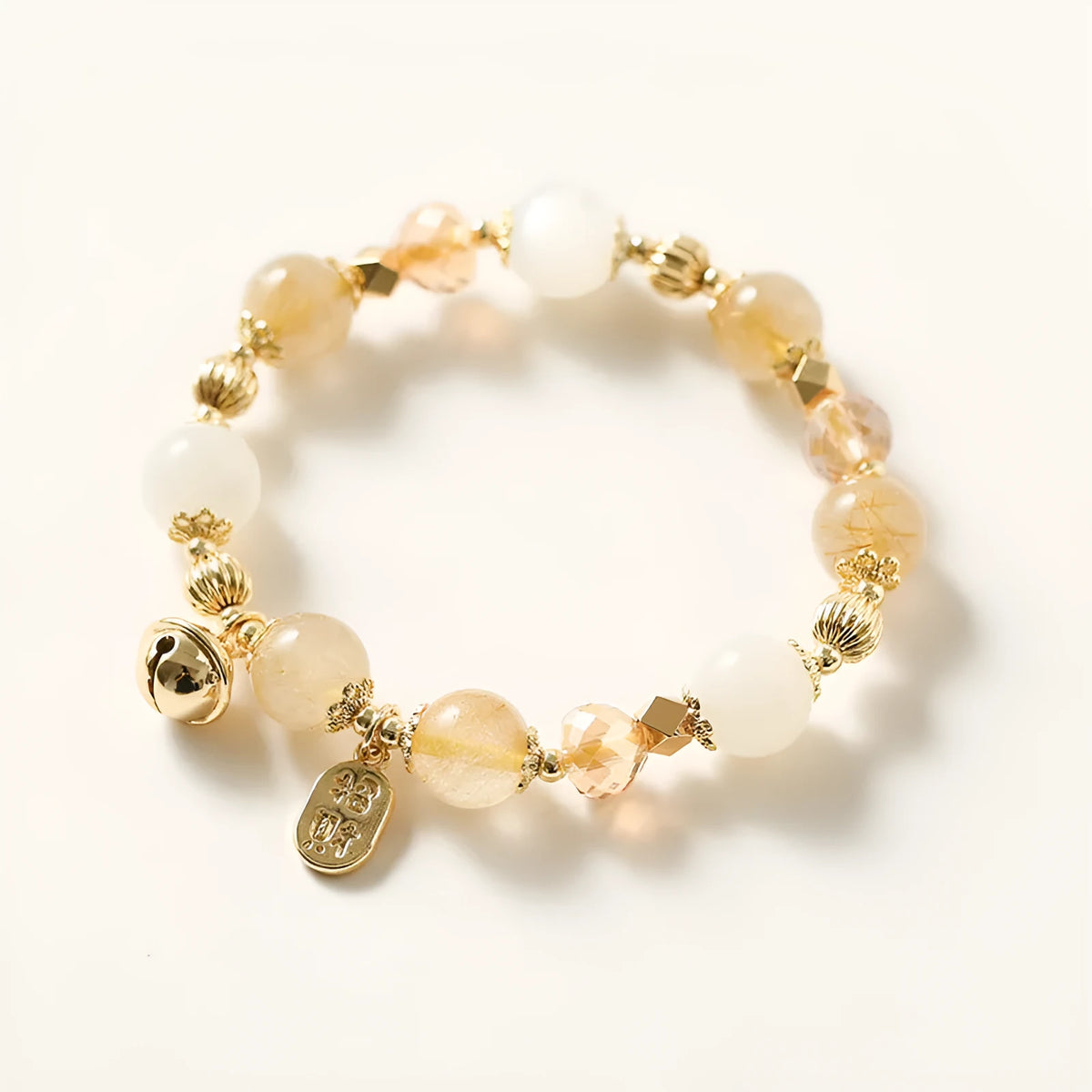 Gold electroplated adjustable bracelet with lucky fortune rutilated quartz crystal beads in a Korean style.
