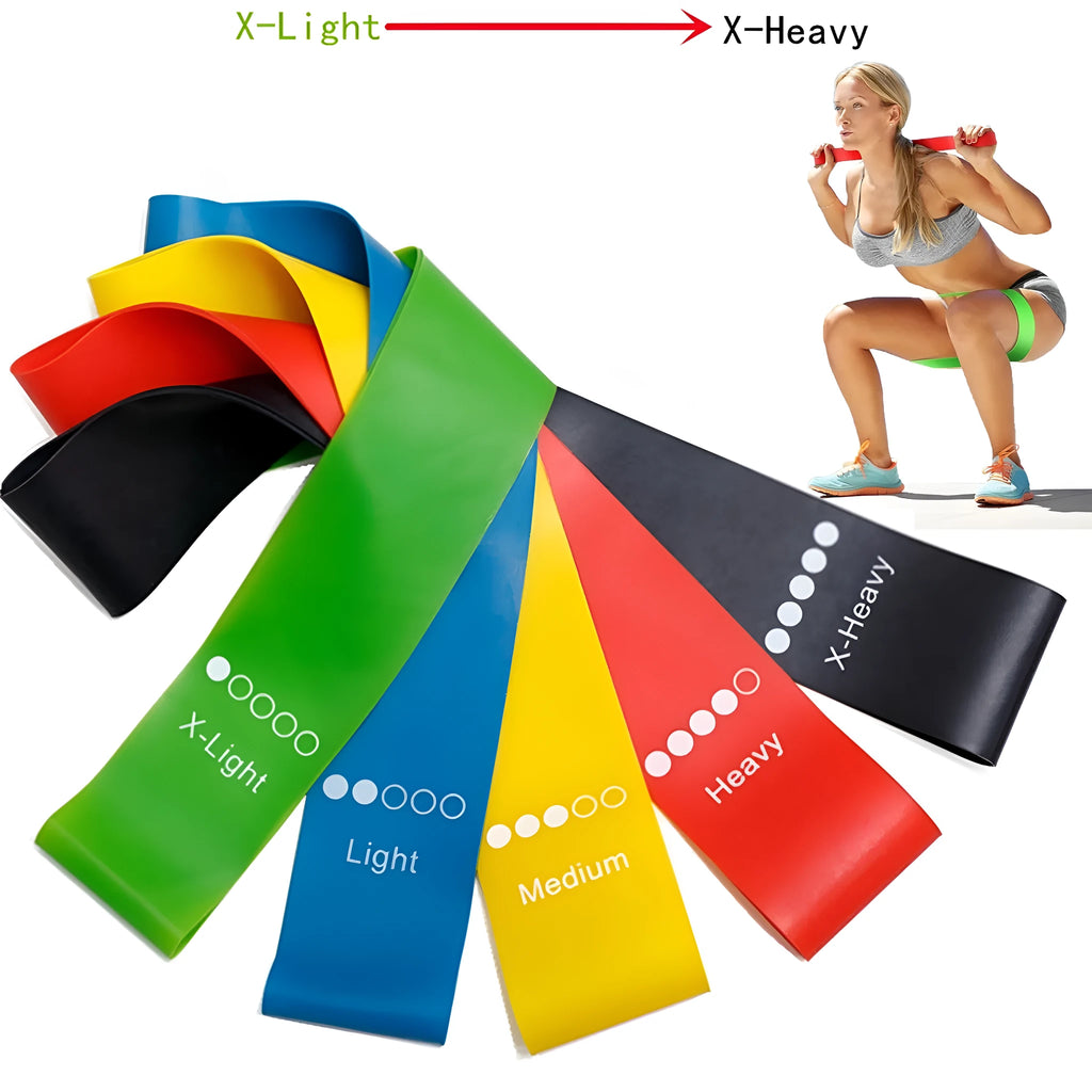 Set of five colour-coded TPE yoga tension straps laid out side by side, showing green, blue, yellow, red, and black options.