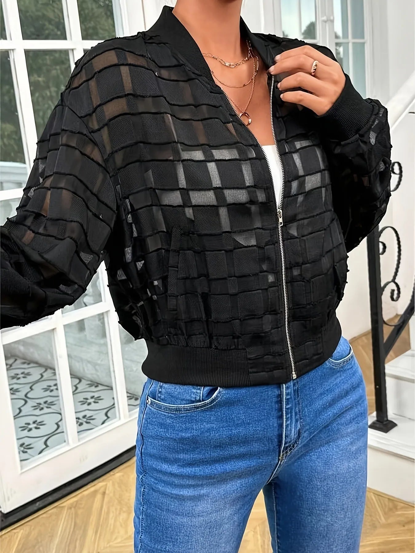 Black women's casual jacket with geometric pattern, semi-transparent fabric, long sleeves, and a front zipper.
