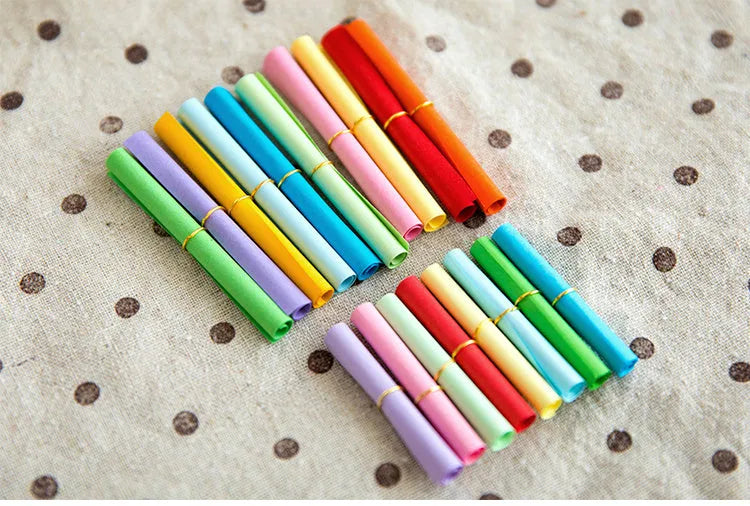 Colourful drift bottle message paper scrolls in various sizes with metal eyelets for hanging.