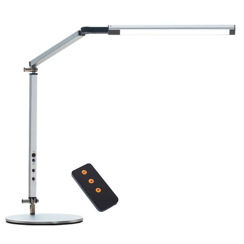 Black folding clip-on LED desk lamp with remote control on a wooden desk.
