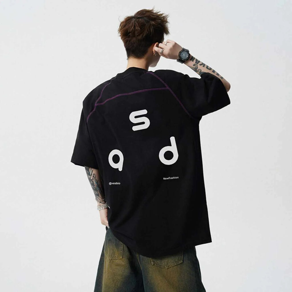 Loose-fitting black cotton T-shirt with a letter print on the chest, showing short sleeves and a round neck.