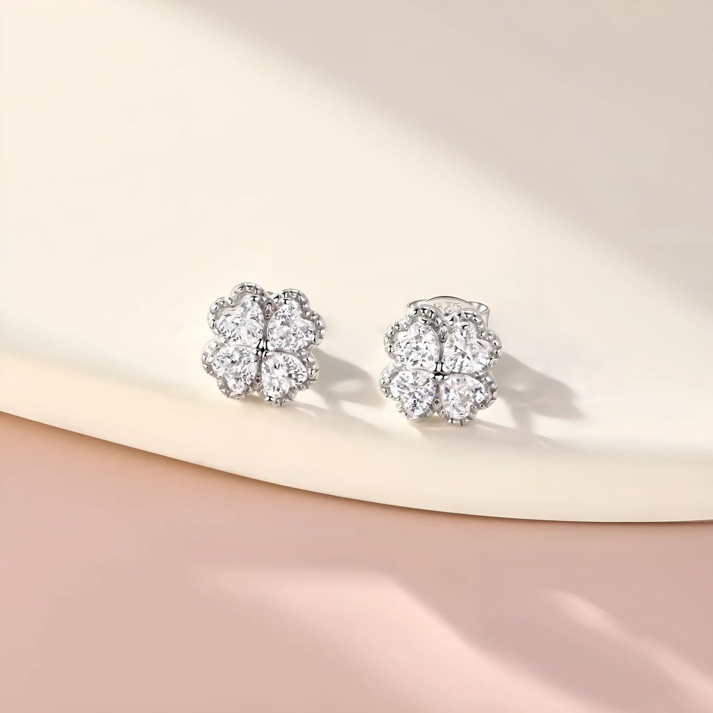 Close-up of women's heart-shaped 925 silver earrings with four-leaf clover zircon inlay, white gold colour finish.