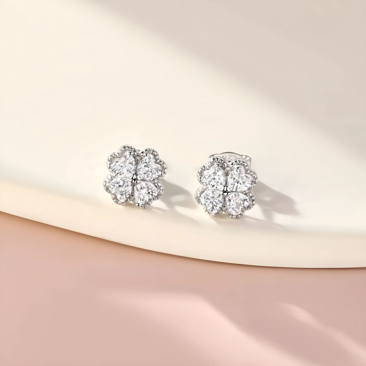 Close-up of women's heart-shaped 925 silver earrings with four-leaf clover zircon inlay, white gold colour finish.
