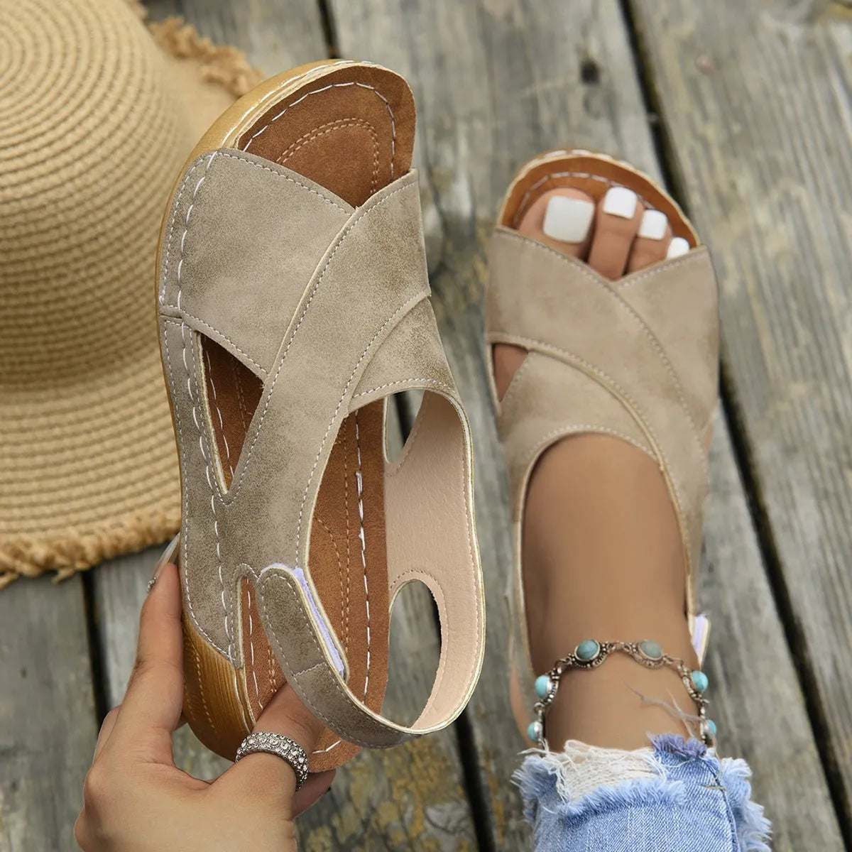 Women's beige Roman-style sandals with a fabric skirt detail, platform sole, and Velcro strap.