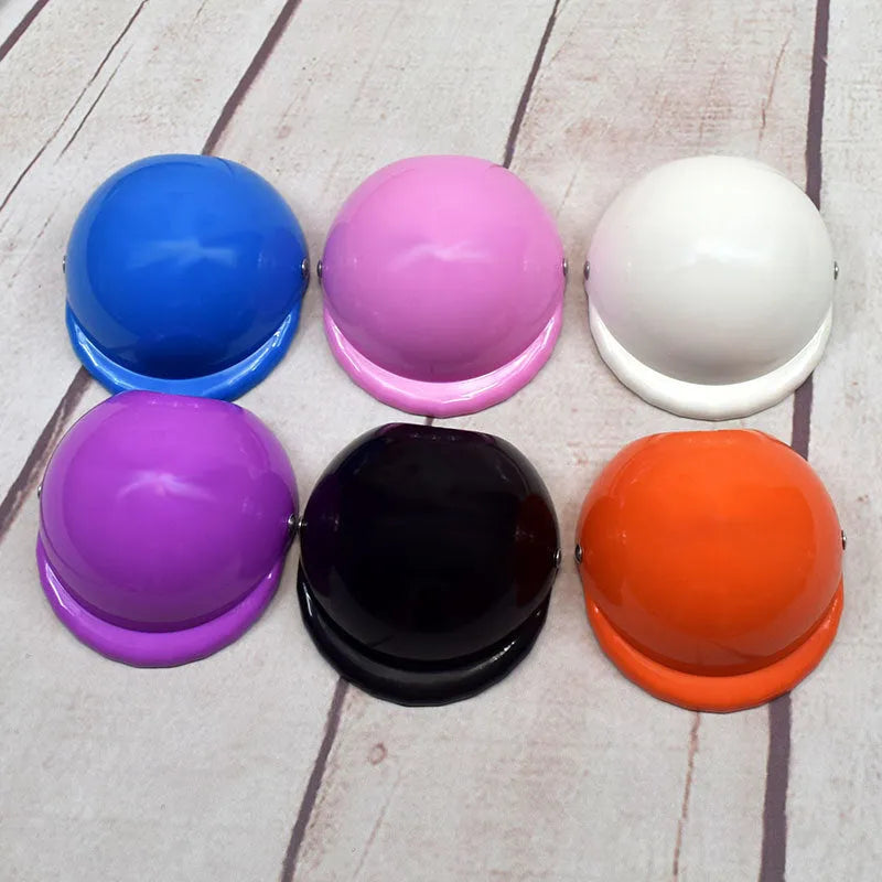 Plastic dog motorcycle cap helmet in assorted colours on a white background