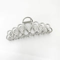 Large minimalist updo hair clip with tassel detail in gold or silver electroplated finish.
