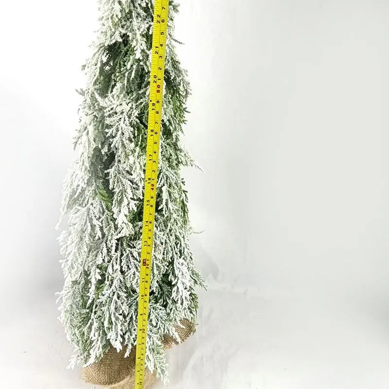 Small white 24-inch plastic Christmas tree with LED lights and simulated snow spray on desktop