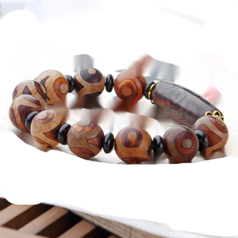 Distressed agate bracelet with traditional Tibetan dzi beads including three-eye and Nine Eyes designs.