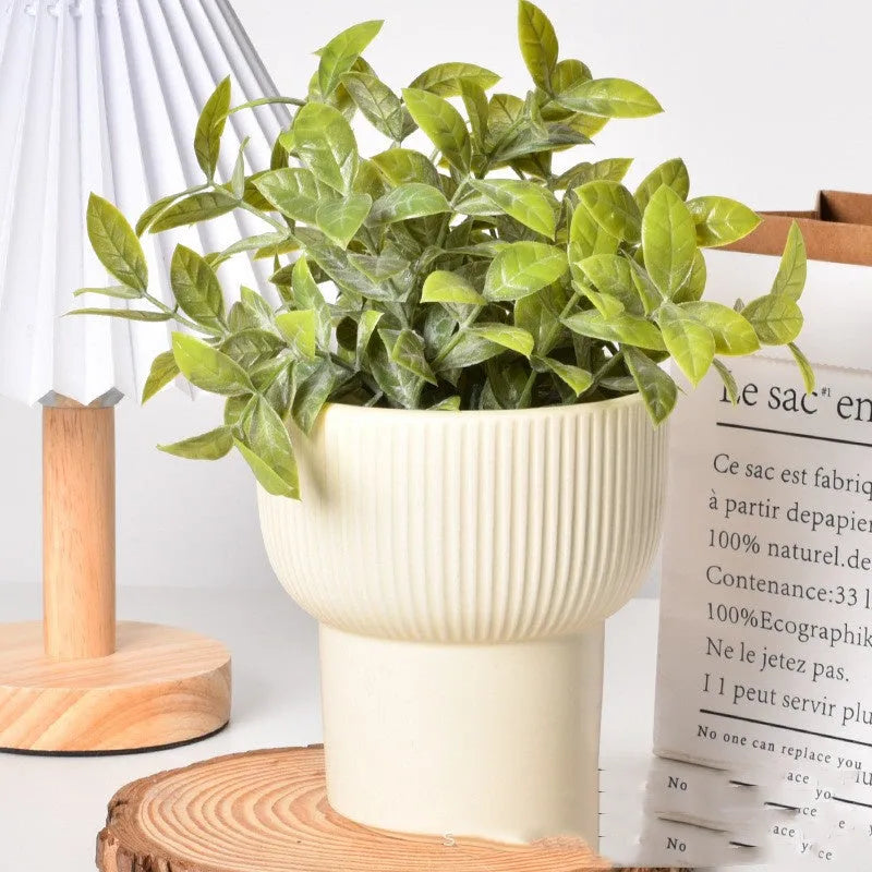 Roman column matte yellow ceramic flower pot on a surface.