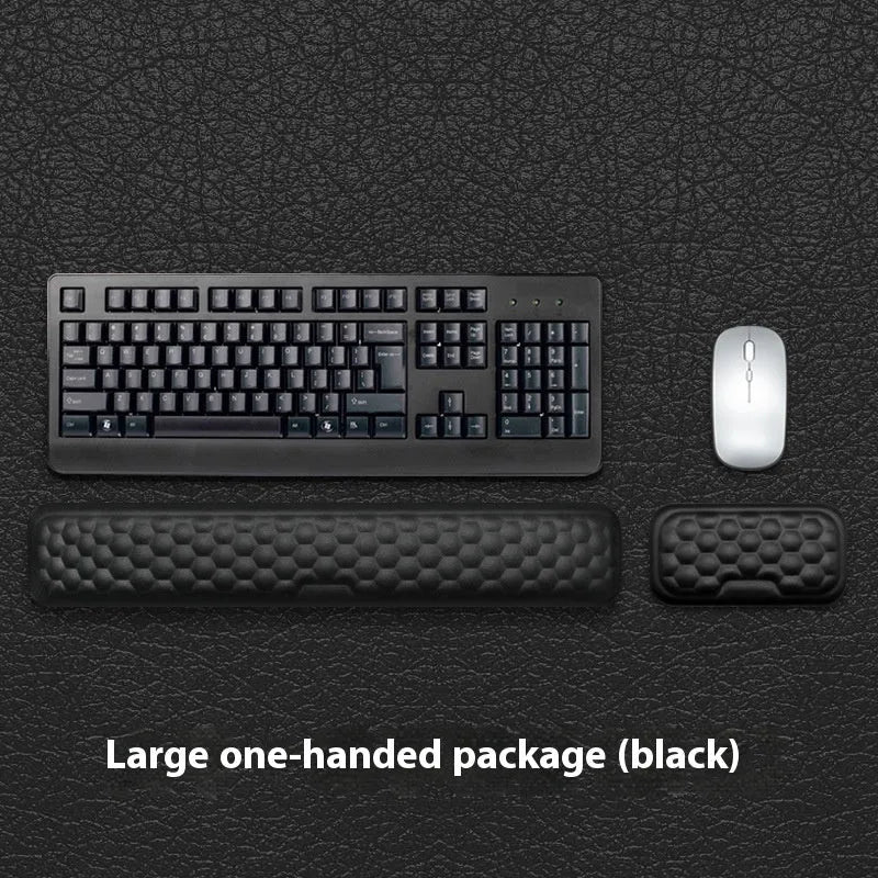 Black memory foam mouse wrist pad with a leather-style cover on a wooden desk
