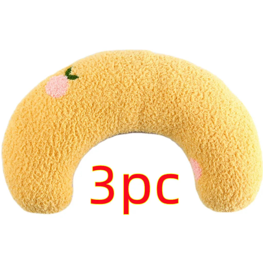 Small blue half-donut shaped pet pillow bed for cats or small dogs on a carpet.