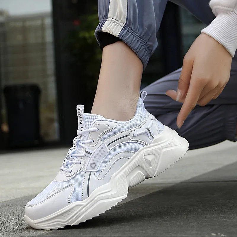 White women's casual sports shoe with mesh upper, thick PU sole, and buckle strap.