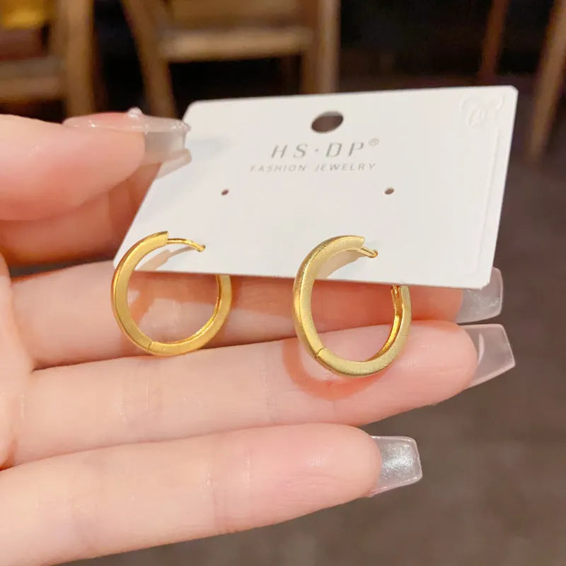 Women's geometric ear clip with round elements in gold plating on copper
