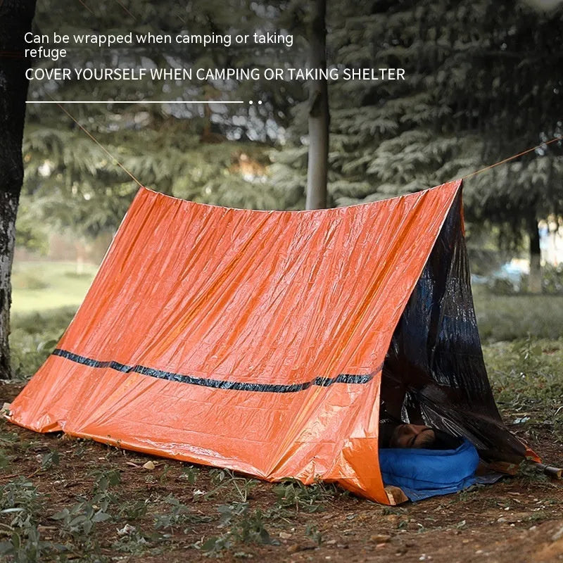 Orange portable outdoor disaster relief tent with emergency blanket and whistle accessory