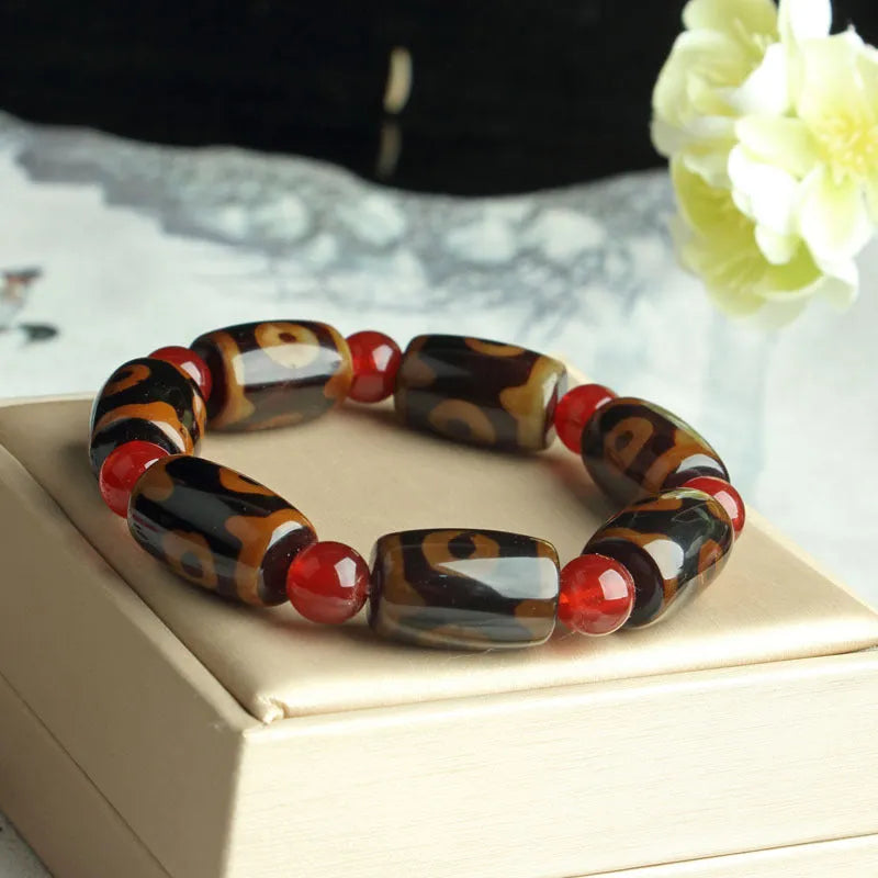 Distressed agate bracelet with traditional Tibetan dzi beads including three-eye and Nine Eyes designs.