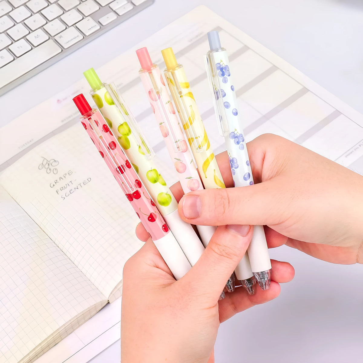 Three fruit scented press-action pens with 0.5mm tips and black ink refills