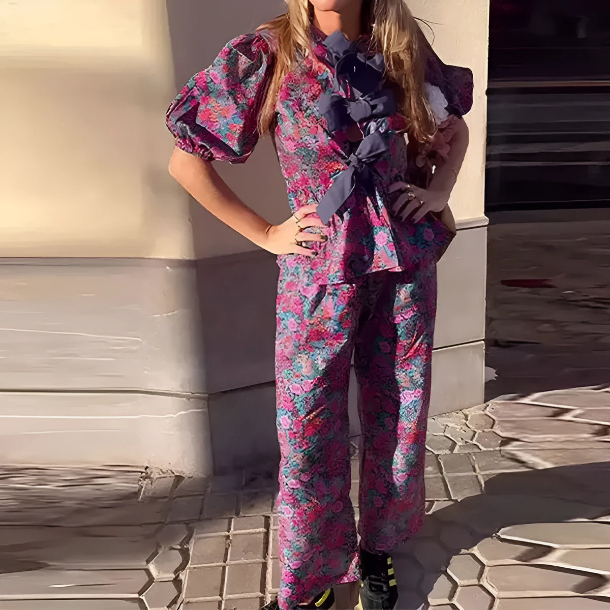 Floral print trousers suit with tie-neck blouse and puff sleeves on hanger