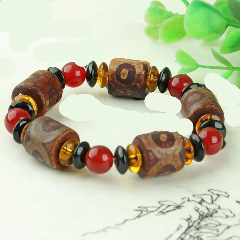 Distressed agate bracelet with traditional Tibetan dzi beads including three-eye and Nine Eyes designs.