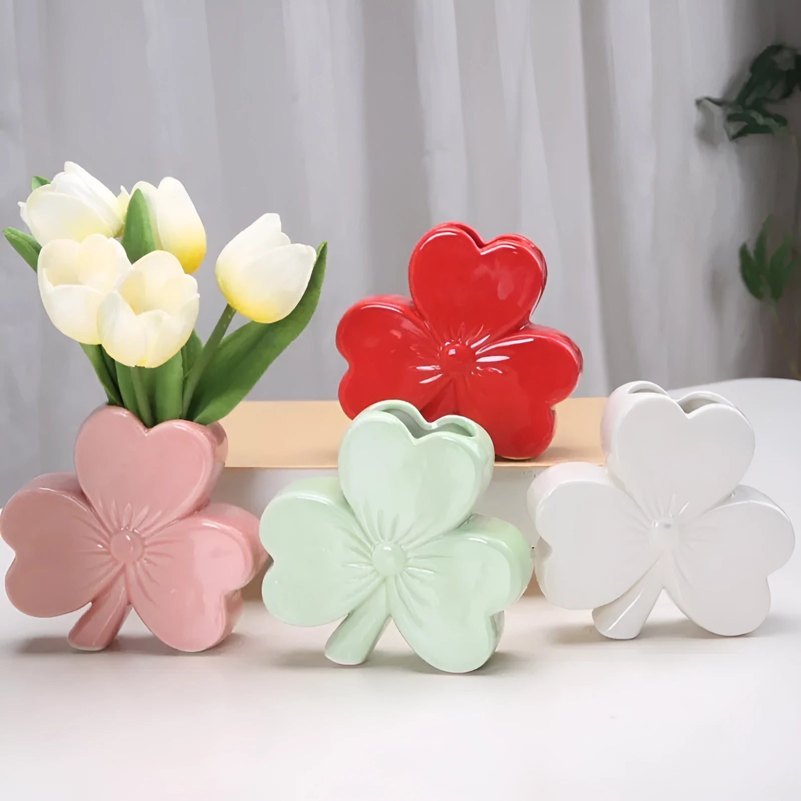 Clover-shaped white porcelain vase in European style on a desktop.