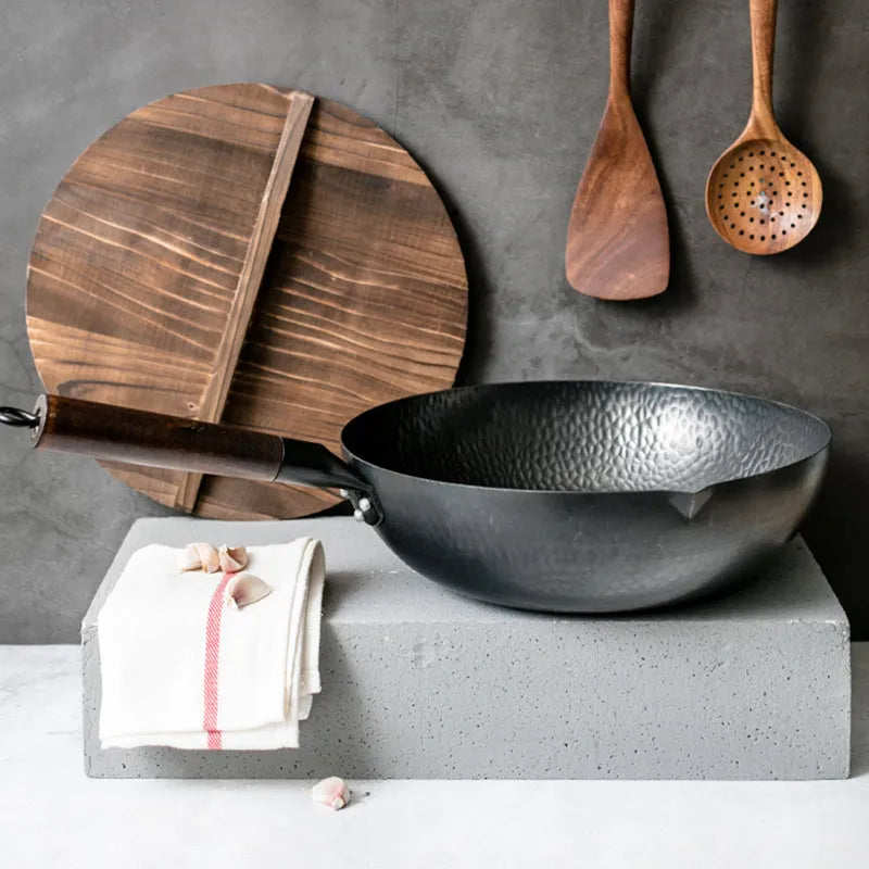 Traditional black iron wok with wooden handle measuring 32cm in diameter