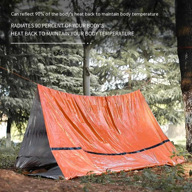 Orange portable outdoor disaster relief tent with emergency blanket and whistle accessory