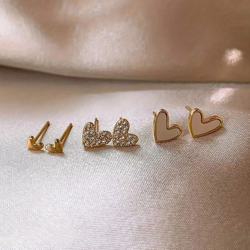Three pairs of women's heart-shaped alloy earrings in gold, black, pink and black-white colours