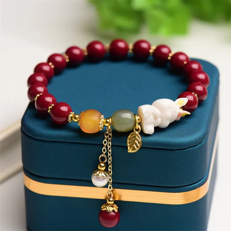 Natural cinnabar bracelet with rabbit charm for women, shown in 8mm and 10mm bead size options.