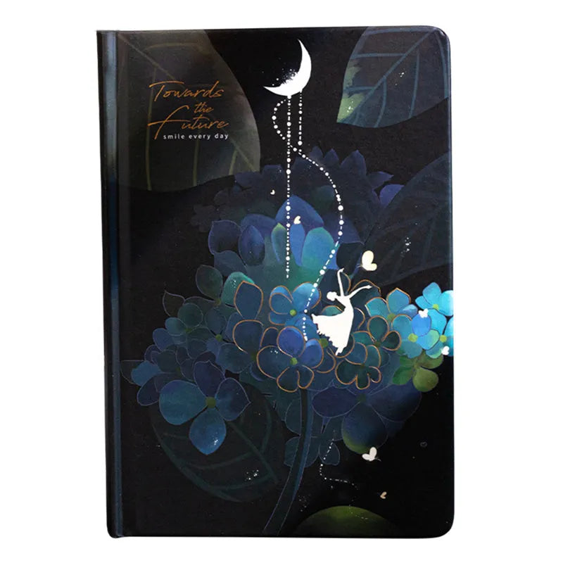 A5 notebook with luminous holographic cover lying flat, showing colourful illustrated interior pages.