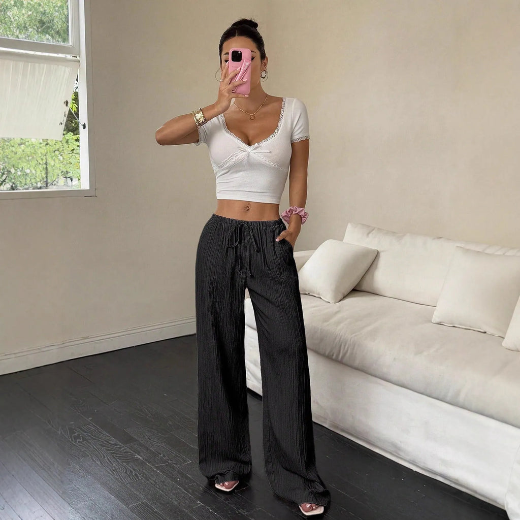 Women's black wide leg trousers with lace-up waist trimming detail on mannequin