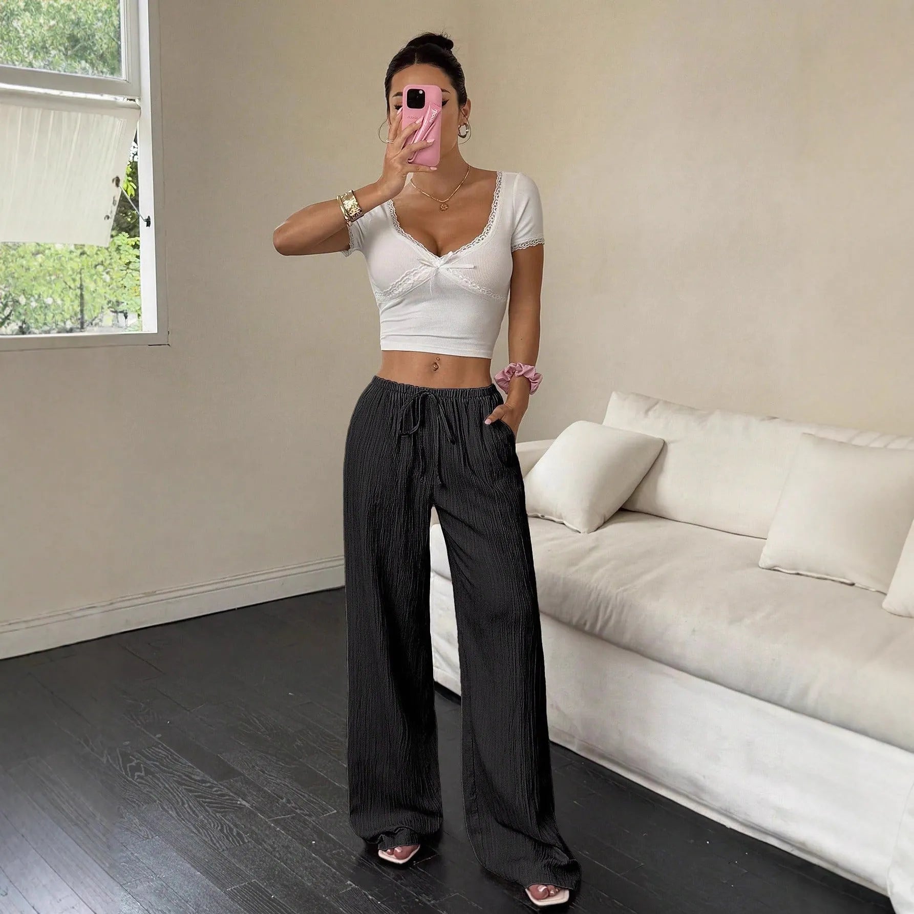Women's black wide leg trousers with lace-up waist trimming detail on mannequin