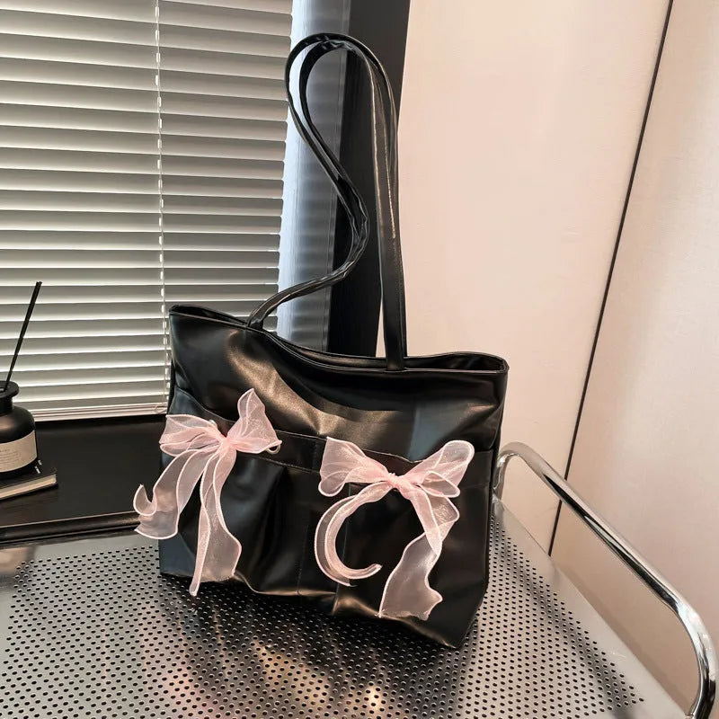 Black college style bow tote bag with double shoulder straps and large main compartment