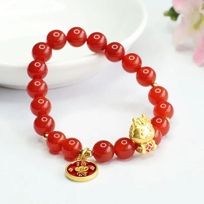 Close-up of a red agate beaded bracelet with a dragon zodiac charm on a wrist.