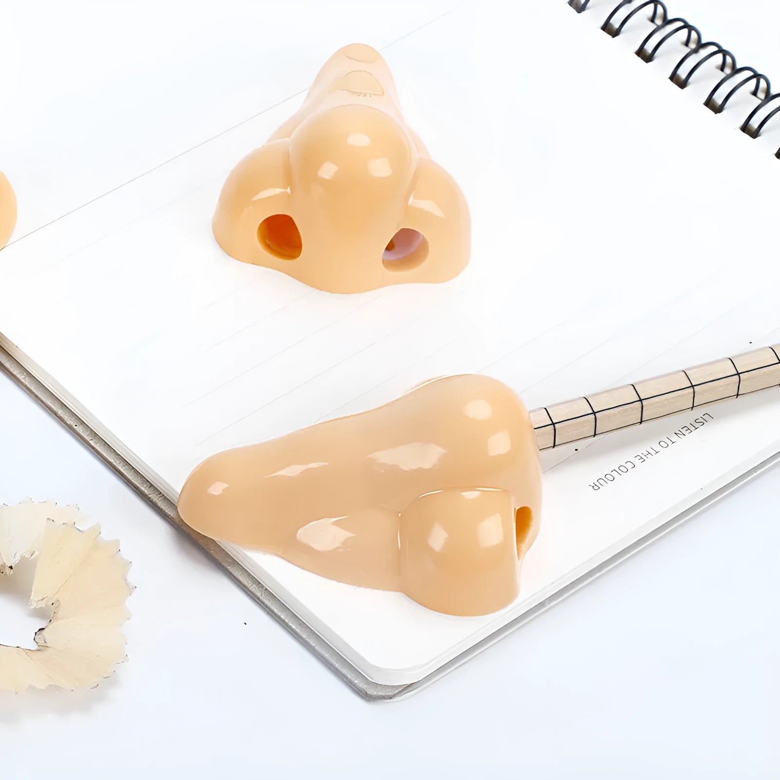 Flesh coloured geometry-shaped plastic manual pencil sharpener on a white background.
