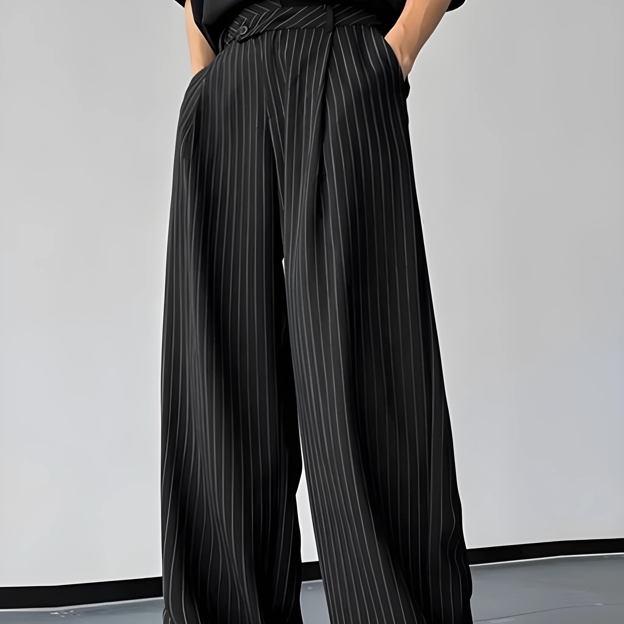 Men's black vertical striped pleated casual trousers with elastic waistband showing front detail