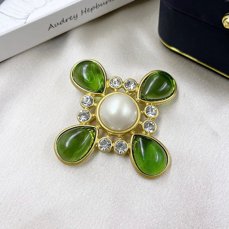 Classic vintage zinc alloy brooch with baroque-style cross design and crystal details on a dark background.