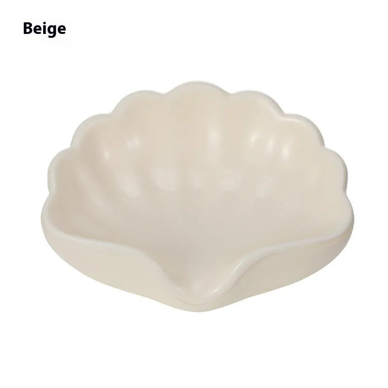 Shell-shaped white plastic soap dish with raised base for bathroom use