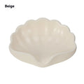 Shell-shaped white plastic soap dish with raised base for bathroom use