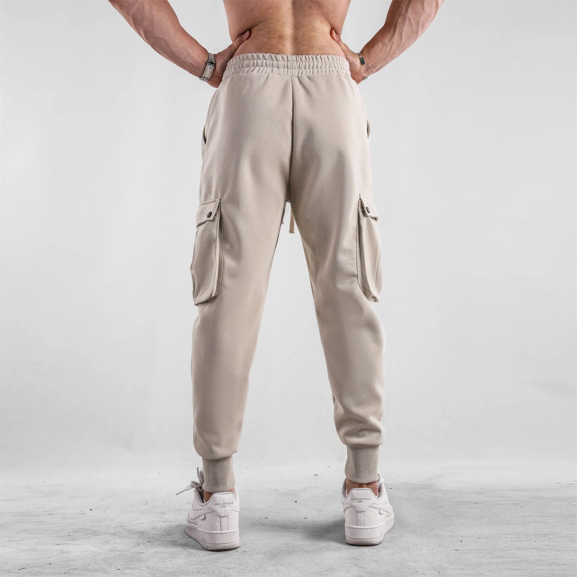 Men's loose cotton sports trousers with ankle tie closure and multiple pockets in solid colour