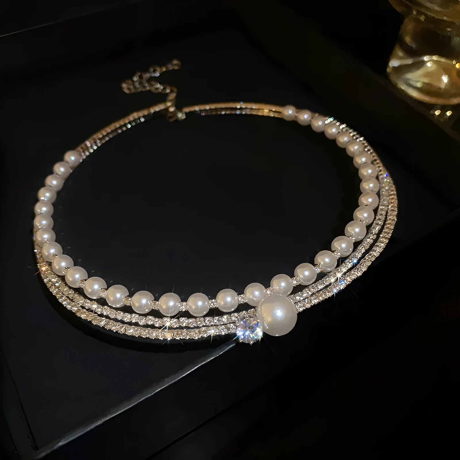 Close-up of a women's silver curved geometric necklace on a clavicle chain.