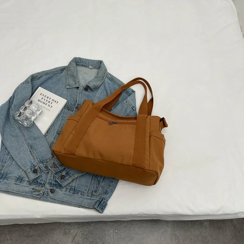 Solid colour polyester tote bag with large capacity and a mobile phone pocket.