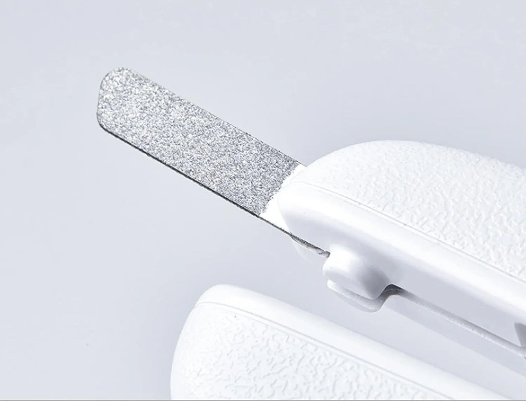 White pet nail clippers with LED light, transparent guard, and leather-like handle next to a nail file.
