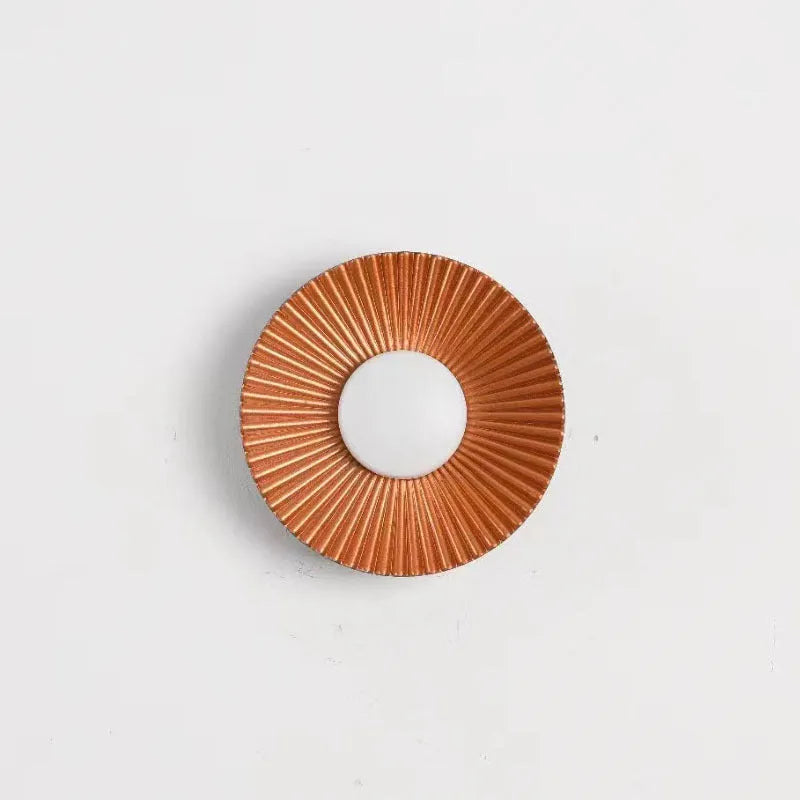 Round aluminium LED wall lamp in outer white and inner gold finish mounted on a wall.