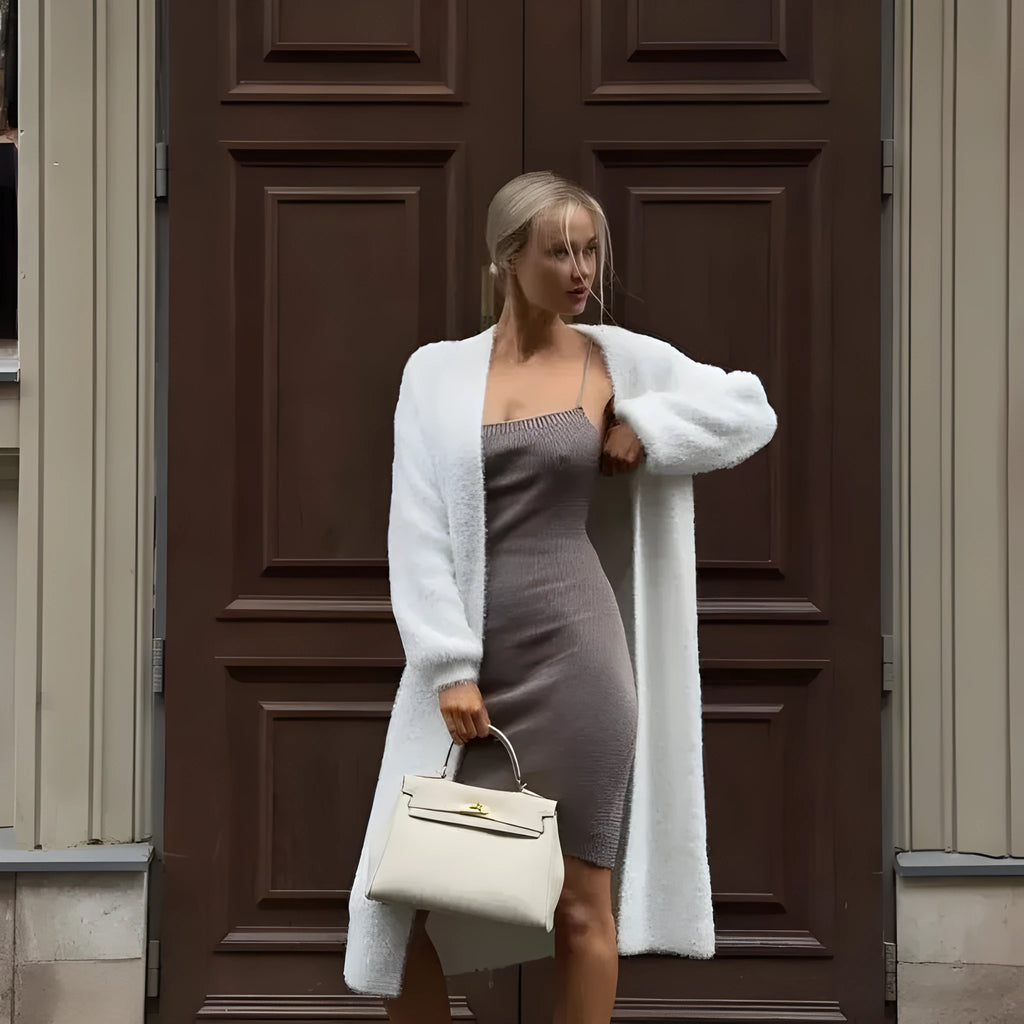 White thick knitted women's cardigan jacket with long sleeves and extended length.