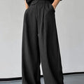 Men's black vertical striped pleated casual trousers with elastic waistband showing front detail