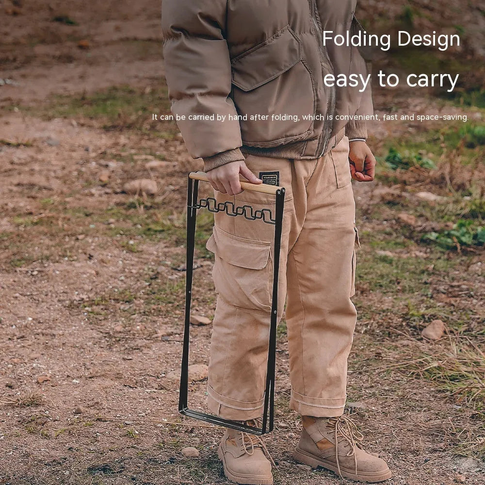 Black folding iron outdoor trash rack with a wooden handle holding a waste bag.