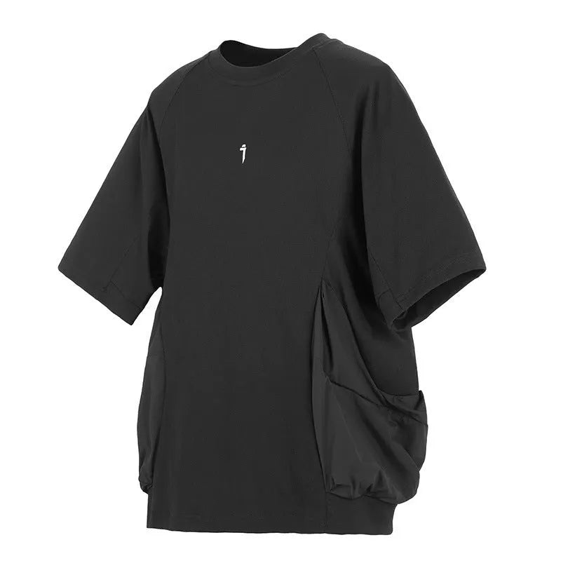 A man wearing a loose grey cotton T-shirt with two large front chest pockets.